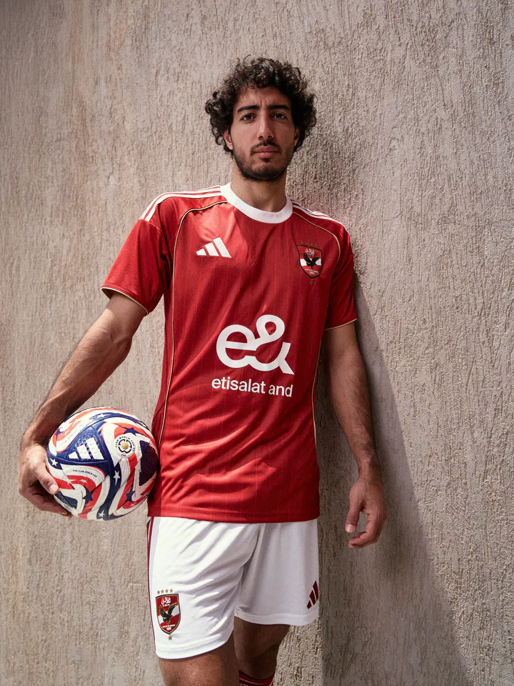 Al Ahly supporters in red matchday kits cheering in a stairwell, from the Adidas × Al Ahly campaign